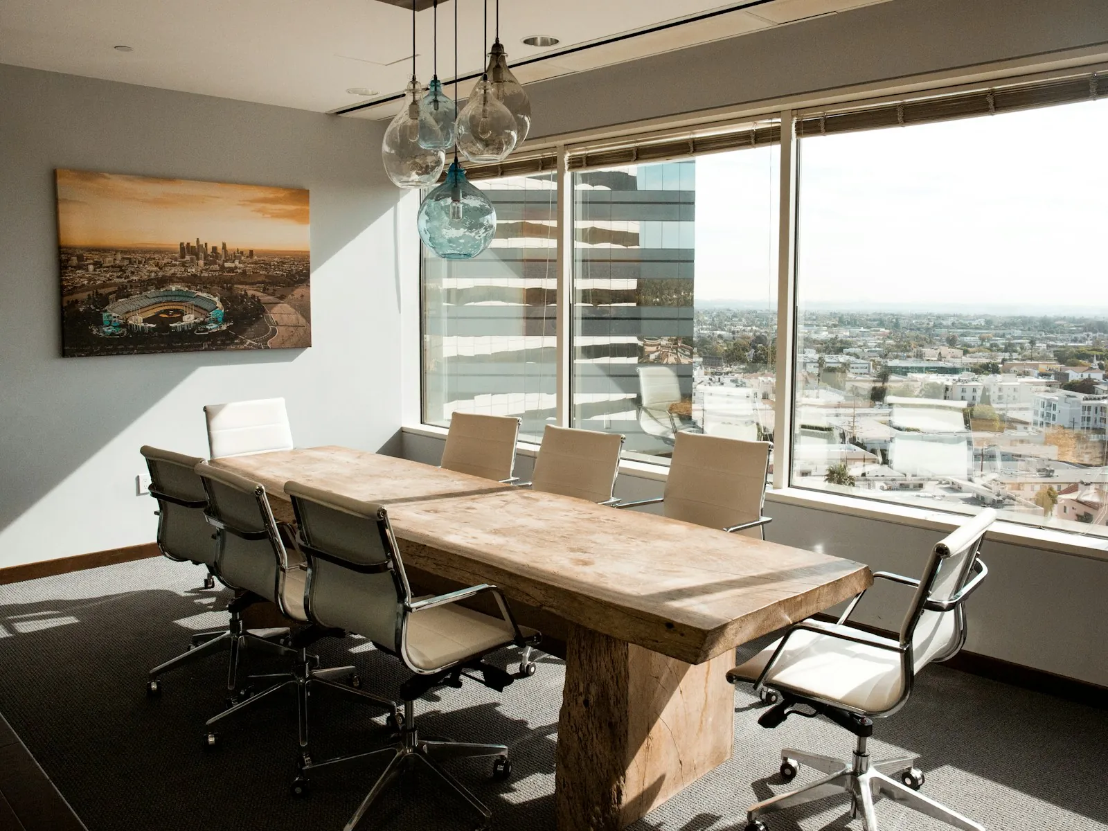 Sala de juntas con mesa de madera y vista a la ciudad